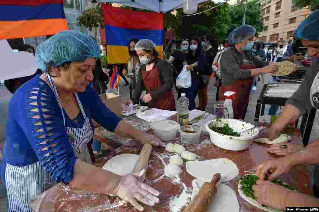 Refugees who fled the Nagorno-Karabakh region make jingalov hats -- traditional flatbreads stuffed with herbs, in central Yerevan on October 26. 