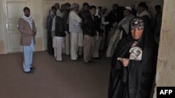 An Afghan woman who was deported from Iran to Afghanistan looks on with other returnees at the provincial refugee agency office in Herat city.