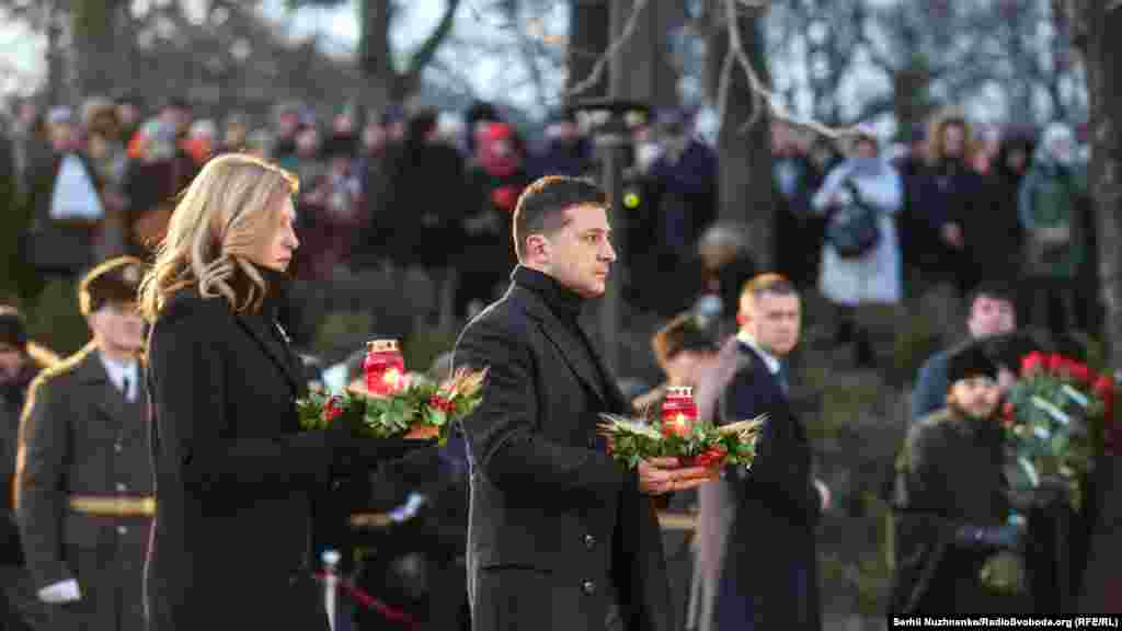 Президент України Володимир Зеленський із дружиною Оленою ставляють лампадки до скульптури «Гірка пам'ять дитинства»