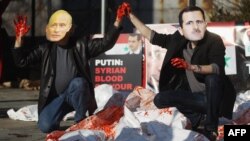 Actors wearing masks of Syrian President Bashar al-Assad and Russian Prime Minister Vladimir Putin perform with body bags during a demonstration outside UN headquarters on January 24.