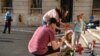 Dramele nu se uită. O familie aprinde lumânări pe scările Ministerului de Interne, iar lângă se află portretul Alexandrei, fata de 15 ani care a fost omorâtă după ce a sunat de trei ori la 112 să anunțe că a fost răpită. Imagine din 27 iulie 2019.