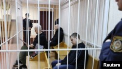Алесь Беляцький і його колеги Валентин Стефанович та Володимир Лабкович сидять у клітці для підсудних під час судового засідання в Мінську. Білорусь, 5 січня 2023 року
