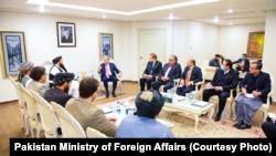 د طالبانو د بهرنیو چارو سرپرست وزیر امیر خان متقي د پاکستان د بهرنیو چارو له وزیر شاه محمود قریشي سره په اسلام اباد کې،۱۸ دسمبر ۲۰۲۱