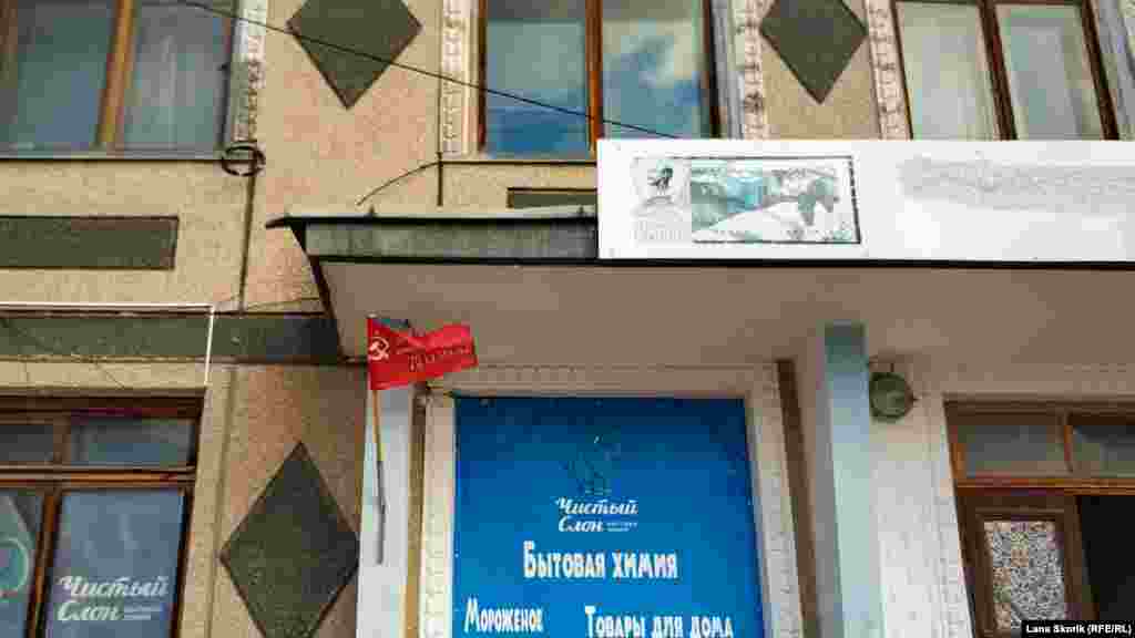 Над входом у магазин на вулиці Леніна – символіка колишнього колгоспу «Пам'ять Леніна» і прапор, що залишився після святкування 9 травня