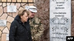 German Chancellor Angela Merkel (left) and Bundeswehr Commandant Erich Pfeffer in front of the memorial to fallen soldiers at the German base in Mazar-e Sharif on March 12.