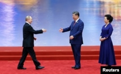 Си Цзиньпин (с супругой) приветствуют российского президента на саммите Шанхайской организации сотрудничества (ШОС)