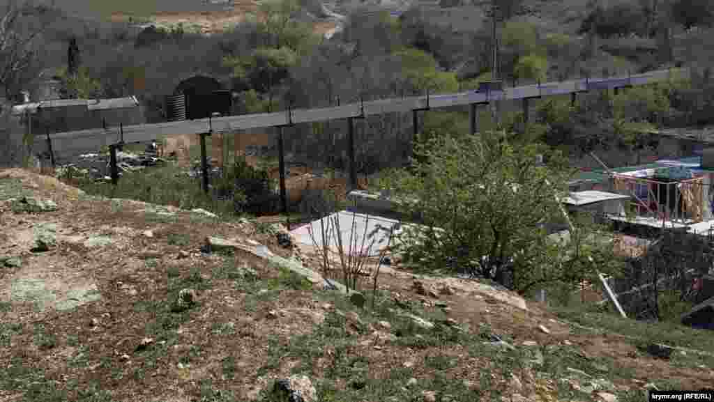 Через яр перекинута теплотраса, за нею – територія військової частини. Раніше тут був підрозділ української 174-ї зенітної ракетної бригади, в лютому-березні 2014 року частина була захоплена російськими військовими