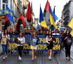 Дівчата тримають портрети Степана Бандери, Ярослава Стецька і Романа Шухевича під час «Маршу тисячоліття Української держави», присвяченого річниці проголошення Акта відновлення Української держави у 1941 році. Львів, 30 червня 2019 року