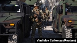 Militari moldoveni, lângă vehiculele HMMWV (Humvee) primite de Armata Națională a Moldovei din partea Statelor Unite, în timpul unei ceremonii la o bază militară din Chișinău, Moldova, 18 februarie 2025.