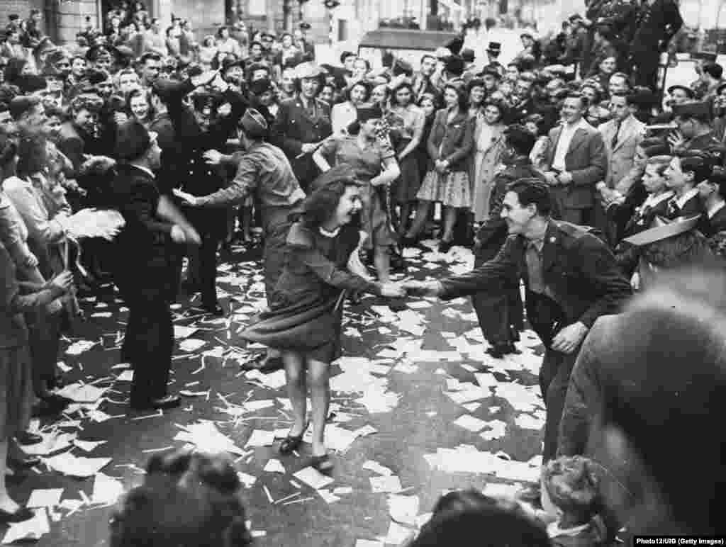 Londra, 8 mai 1945, ziua în care a capitulat Germania nazistă - femeile britanice dansează pe străzi cu soldații americani .