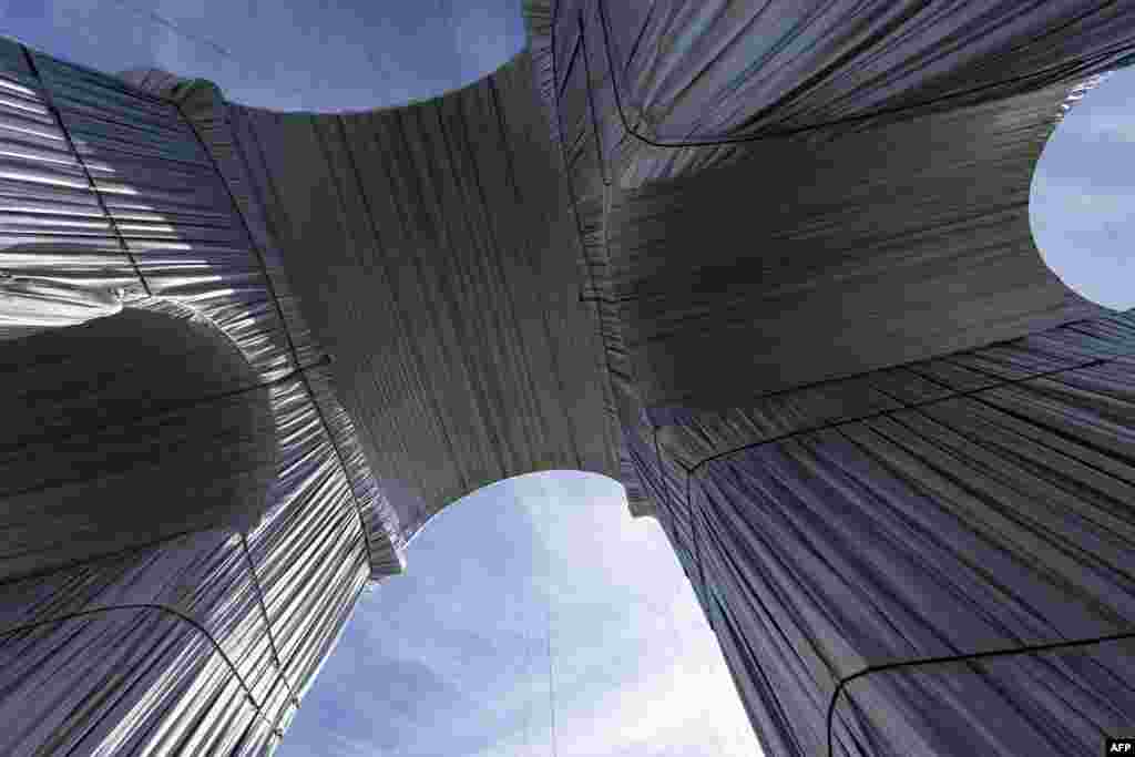 50-метровия военен монумент е опакован с  25 000 квадратни метра сребристо син полипропилен и 3 000 м червено въже.