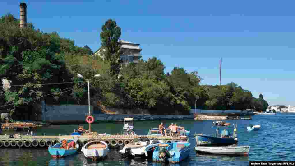 На сусідній дерев'яній пристані відпочиває компанія чоловіків