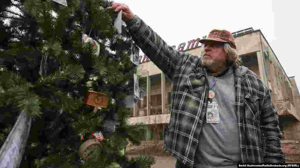 Колишній житель Олександр Демидов вішає фотографії на ялинку. Він в той час був диск-жокеєм в будинку культури «Енергетик»