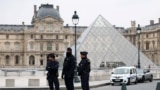 Полицейские стоят возле пирамиды музея Лувр после сообщения об ограблении в Париже, Франция, 19 октября 2025 года. REUTERS/Gonzalo Fuentes