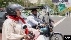 A man and a woman ride their motorcycles in central Tehran. (file photo)