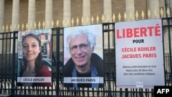 This photograph shows portraits of French national Cecile Kohler (left) and her partner French Jacques Paris, along with a placard calling for their release, Paris, March 25