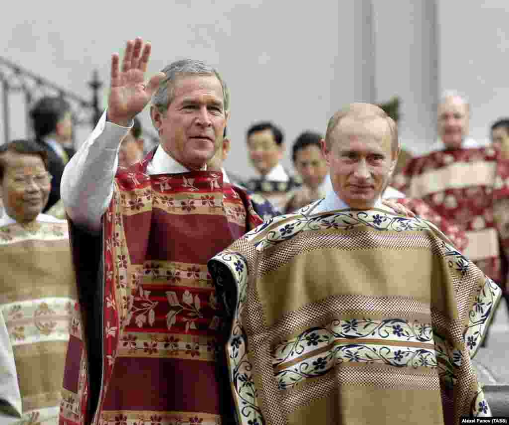 Vladimir Putin și George W. Bush poartă poncho-uri chiliene la sosirea la sesiunea foto oficială a liderilor APEC de la palatul La Moneda din Santiago de Chile, pe 21 noiembrie 2004.