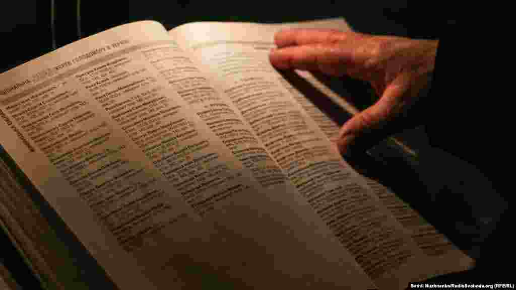 Люди в книзі пам'яті шукають імена померлих родичів