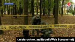 Egy helyi tévéállomás riportjában orosz nyomozók kutatnak át egy lezárt területet.