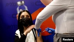 Духтари исроилӣ ҳангоми гирифтани ваксина.