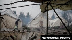 A migrant walks through puddles inside the Vucjak camp near Bihac in Bosnia.
