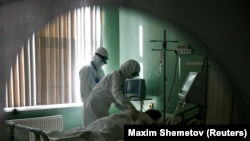 Russian medics treat a patient suffering from COVID-19 in the intensive care unit of a hospital in the Russian city of Orel.