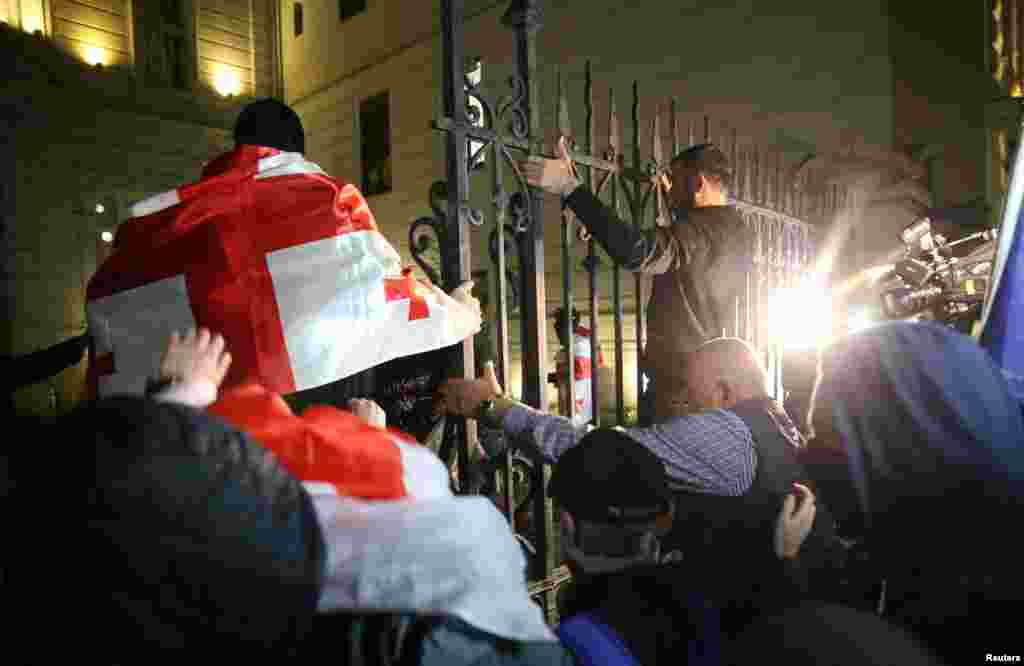 Протестующие пытаются прорваться на территорию президентского дворца во время митинга оппозиции в день местных выборов в Тбилиси, Грузия, 4 октября 2025 года. REUTERS/Irakli Gedenidze