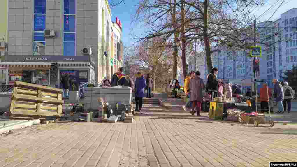На зупинці «Юмашева» вуличні торговці використовують піддон із тротуарною плиткою як прилавок
