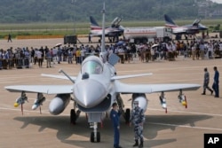 Personeli ushtarak kinez pranë një avioni luftarak J-10C. Shtator, 2021.
