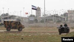Turkish troops take up position at the Akcakale border gate in southern Sanliurfa province on the border with Syria on October 7.
