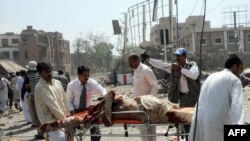 Volunteers transport an injured victim at the scene of the suicide car-bomb attack in Lahore on May 27.