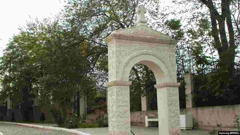 Арка біля входу на подвір'я храмового комплексу з написом «Благословення святої обителі»