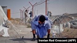 An Afghan man sits at the border between Afghanistan and the southeastern Iranian province of Sistan-Baluchestan.