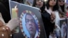 People hold candles in front of a portrait of the Sri Lankan worker who was lynched by a mob over allegations of blasphemy in Lahore in December.