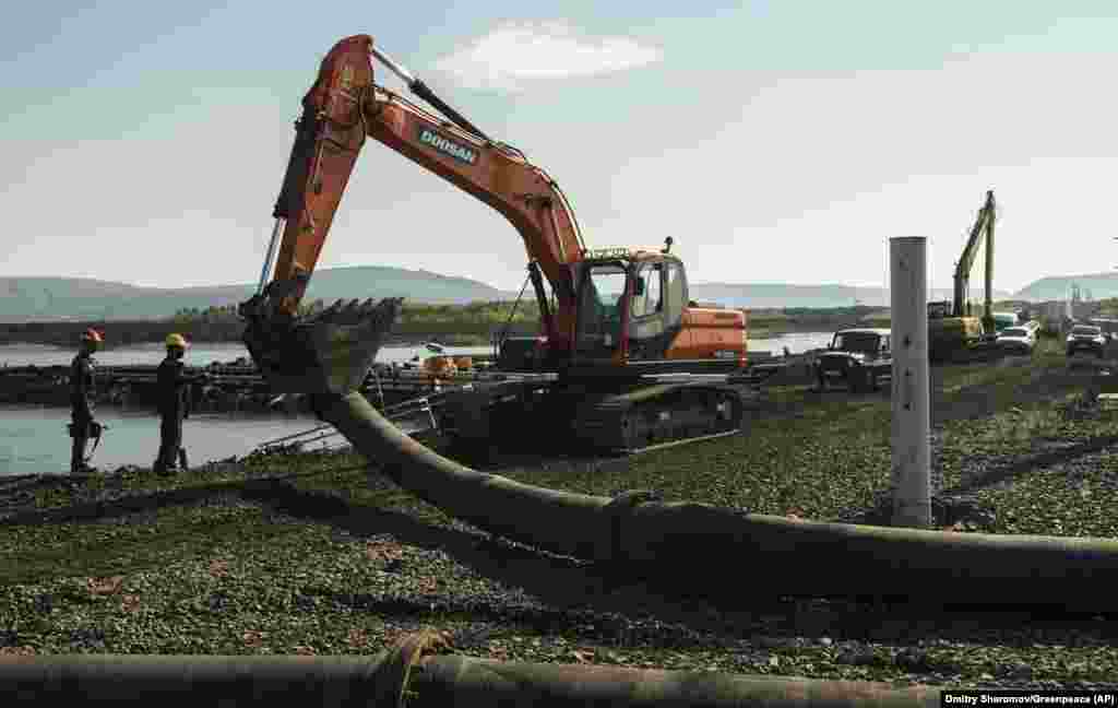 This photo released by Greenpeace on June 28 shows an excavator disassembling a pipe from a Norilsk Nickel enrichment plant that was draining water into a river. The company said that it improperly pumped wastewater into the Arctic tundra and that it has suspended the employees responsible for the error.