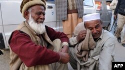 Men react after learning that their relatives were among those killed in the bomb blast in Nowshera.