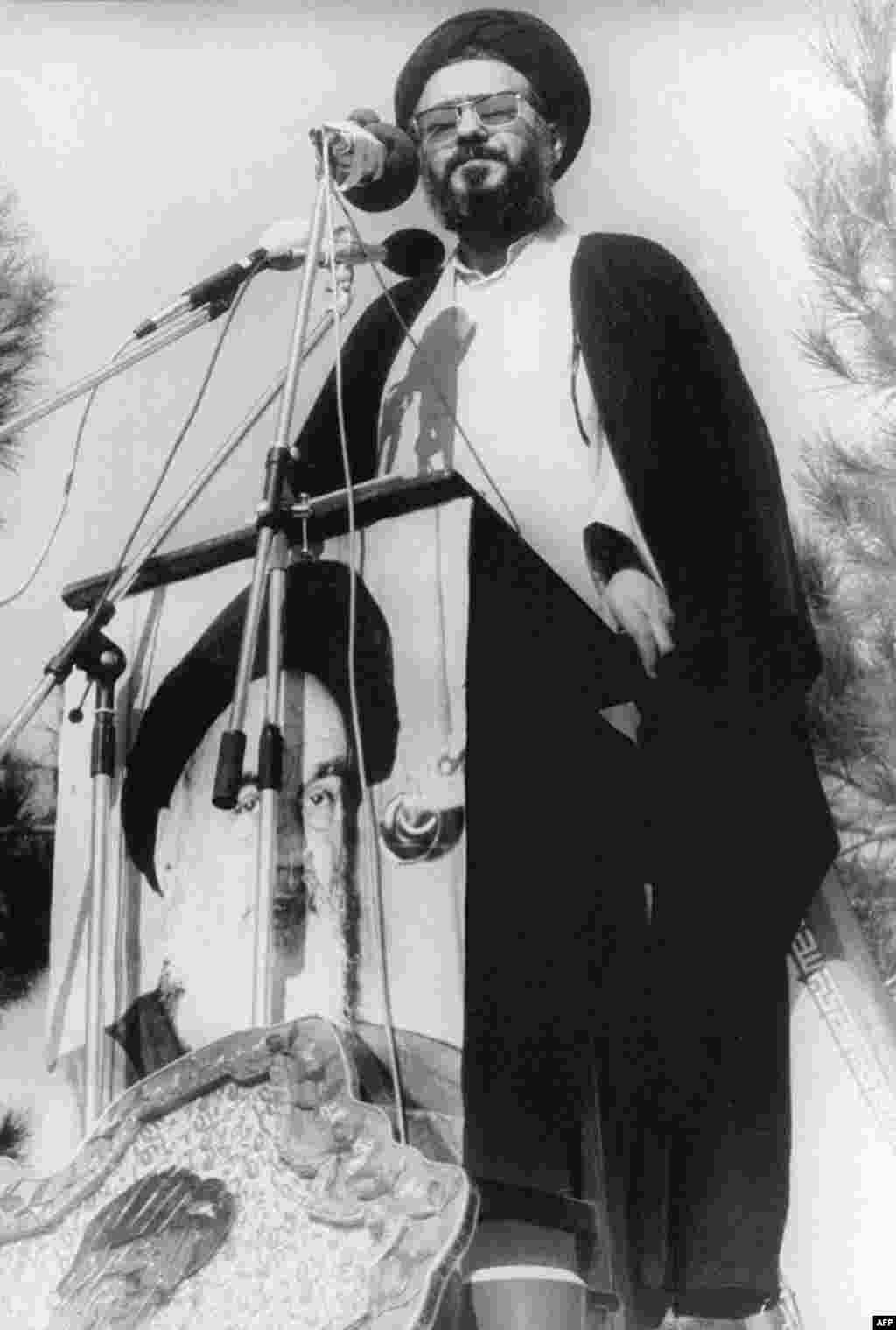 Student leader Ayatollah Musavi Khoeniha speaks from the top of a U.S. Embassy wall on the siege's first anniversary.
