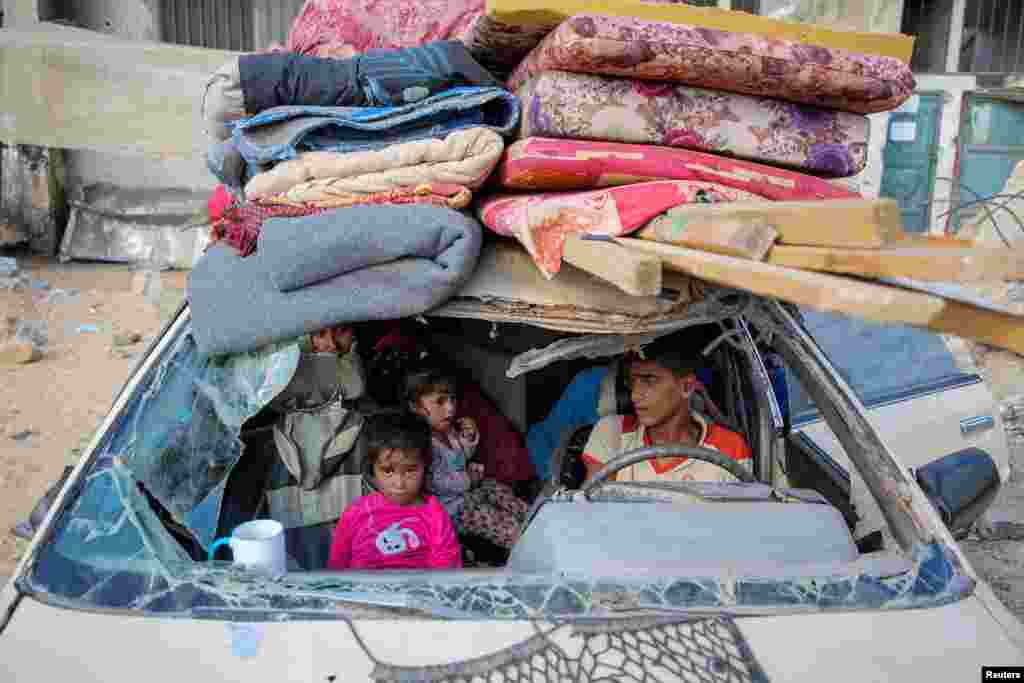 Перемещенные палестинцы сидят в поврежденном автомобиле, покидая районы в восточной части Хан-Юниса после приказа Израиля об эвакуации, на фоне продолжающегося конфликта между Израилем и ХАМАС, в Хан-Юнисе на юге сектора Газа 7 октября 2024 года. 