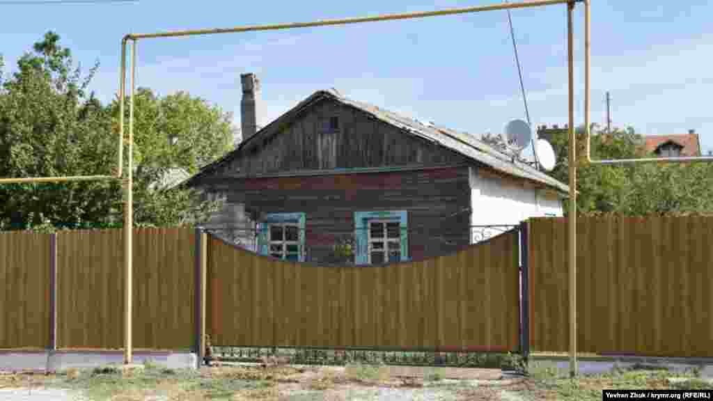 Старий дерев'яний будинок – за новим парканом