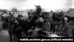 Розпродаж з молотка майна розкуркуленого селянина Мартиненка на «червоному базарі» в с. Удачне Гришинського району Донецької області. Виступає Марія Кубрячка. Місце і дата зйомки: с. Удачне, 1930-1932 Автор зйомки: Марко Железняк.