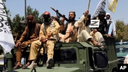 Taliban fighters celebrate the third anniversary of the withdrawal of U.S.-led troops from Afghanistan on August 14.