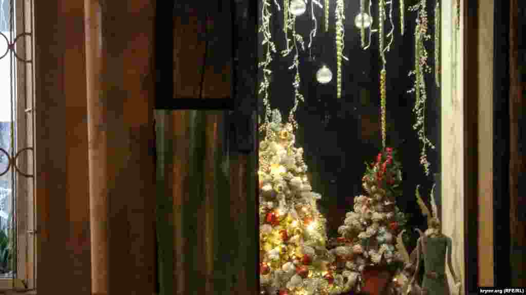 Витрины магазинов, кафе и различных заведений в городе изобилуют гирляндами и елками 