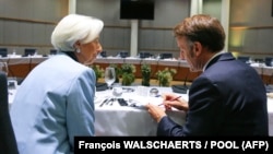 Президент Европейского центрального банка Кристин Лагард беседует с президентом Франции Эммануэлем Макроном на саммите в Брюсселе, 23 октября 2025 года