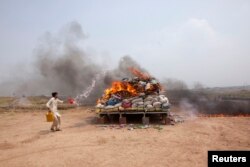 اسلام اباد کې د نشه يي موادو ضد ادارې یو کارکوونکی نشه يي توکي سوځوي - پخوانی انځور.