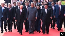 Председатель КНР Си Цзиньпин (в центре) и иностранные лидеры, включая президента России Владимира Путина (в центре слева) и лидера Северной Кореи Ким Чен Ына (в центре справа), идут к трибуне перед церемонией в честь 80-й годовщины капитуляции Японии во Второй мировой войне