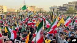 24 iunie 2025, Teheran, Iran. Protestatarii flutură steaguri iraniene și bannere ale liderului suprem Ayatollah Ali Khamenei în timp ce scandează sloganuri împotriva SUA și împotriva Israelului.