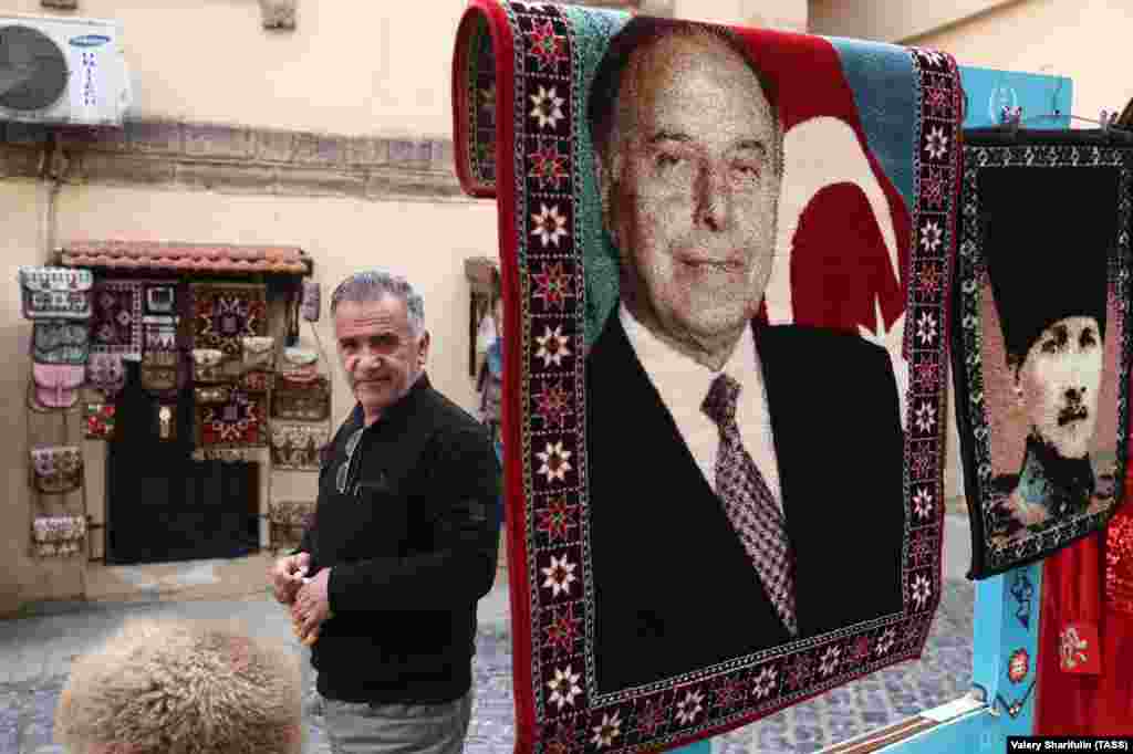 A man selling carpets with the image of former Azerbaijani President Heidar Aliyev (left) and Mustafa Kemal Ataturk, the founder of modern Turkey. Aliyev famously described Turkey and Azerbaijan as "one nation, two states." 