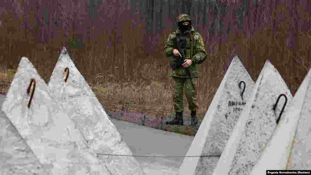 Белорусский военный патрулирует границу с Украиной. На фото – противотанковые укрепления, так называемые "зубы дракона"