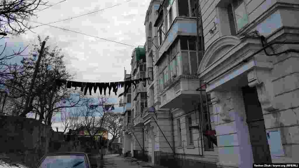 Величні входи в під'їзди і розвішана білизна. Увінчані красивими капітелями напівколони розташовані на зверненому на захід головному фасаді будинку. Барельєфи у вигляді амфор виконані на рівні четвертого поверху, на головному і на бічних фасадах