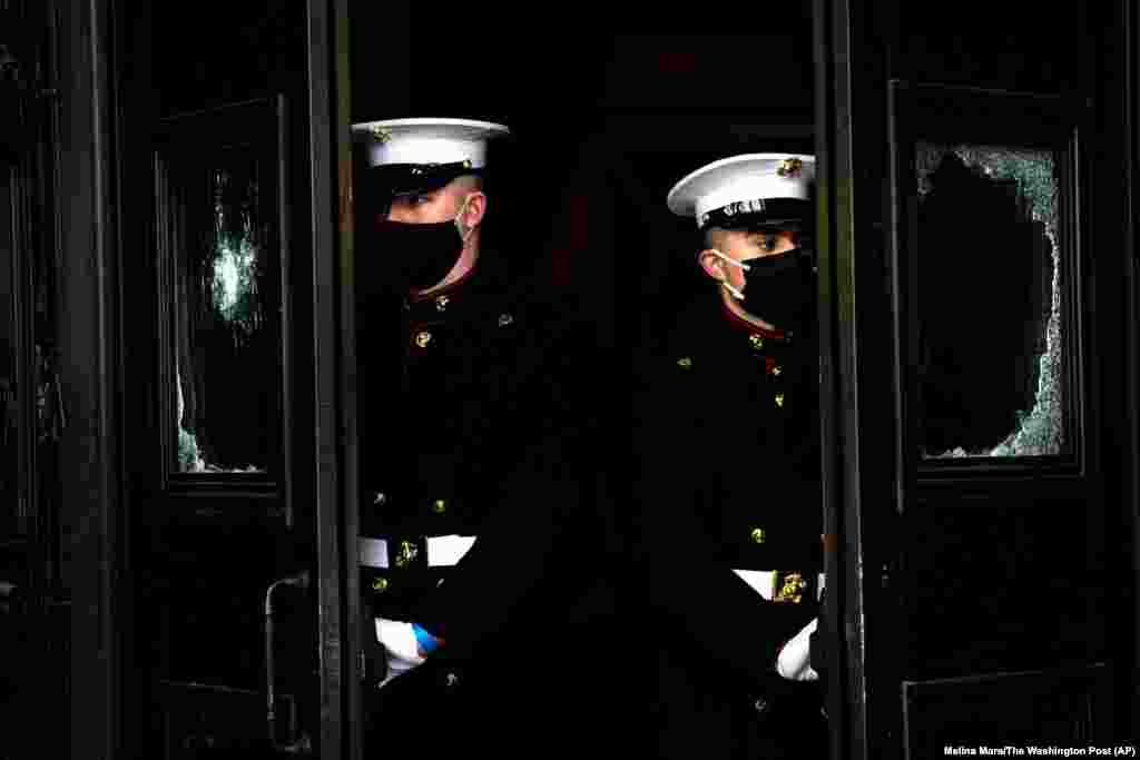 Корпус морської піхоти США тримає пошкоджені двері Капітолію під час репетиції церемонії вступу на посаду обраного президента Джо Байдена та обраної віцепрезидентки Камали Гарріс, 18 січня 2021 року